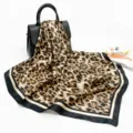 Detailed view of brown leopard print satin square scarf displayed on a chic handbag, 90cm. - D9198 - Black Edge