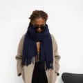 Detailed view of a dark blue solid color tassel scarf, elegant winter warm design. - Navy Blue
