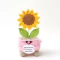 Close-up detail van handgemaakte gehaakte zonnebloem pop, schattige gebreide plant decor. - Roze