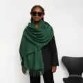 Detail view of a solid green tassel cashmere-feel scarf, cozy winter warm long shawl wrap for women. - Dark Green