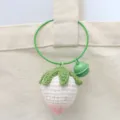 Gedetailleerd overzicht van de handgemaakte gehaakte aardbeitasbedel met mooie ring en stijl. - Witte aardbei met draadring