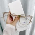 Detailansicht der modischen Retro Blaulichtfilter Brille mit eleganter Handpräsentation. - Sandbraun / Blaulichtschutz (ohne Stärke)