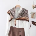 Vista dettagliata del foulard quadrato da donna con stampa elegante a catena e monogramma. - Catena di Lettere