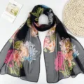 Gros plan détail d'un foulard en mousseline noir pour femmes avec motif de pivoines colorées. - Noir