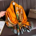 Luxurious orange silk scarf for women, featuring elegant floral prints and stylish geometric borders. - Earth Yellow Flowers