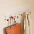 Wandmontierter Garderobenständer, minimalistischer Haken aus Metall und Holz für Diele und Flur. - Cremeweiß