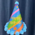 Kids birthday cone hat with blue pom poms and colorful stripes party decoration detail - Blue Cone Hat / Blue