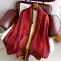 Red retro patterned long silk scarf shawl, detailed view hanging on a leather chair. - Longevity Pattern