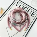 Vista di dettaglio del foulard rosa con stampa floreale e ciondoli magnetici dorati. - Modello con chiusura magnetica 1