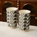 Set of 10 ceramic rice bowls featuring an elegant black and white floral pattern design. - 4.5-inch Rice Bowls - 10 Pieces