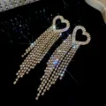 Close-up of luxury sparkling zircon heart tassel earrings, brilliant diamond detail for party. - Gold