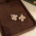 Detailopname van glinsterende perzik kristal bloem clip-oorringen in een fluwelen bruine doos. - Clip-oorbellen / Zilver-Koffie