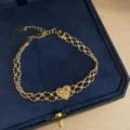 Detail view of a vintage gold-toned double mesh chain bracelet featuring an ornate heart charm. - Gold Heart