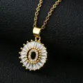 Close up of gold tone letter O pendant necklace with sparkling cubic zirconia baguette stones. - Gold Letter O