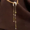 Primer plano detallado de la orejera de perlas y estrellas con cadenas colgantes elegantes. - 3762 oro