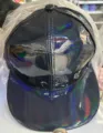 Gros plan détail de la casquette de baseball plate en cuir PU holographique noir brillant et coloré. - Noir Bord Plat