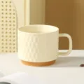 Keramik Kaffeetasse Detail, geprägtes Rautenmuster, cremeweißer Becher mit braunem Boden. - Milchgelb