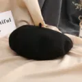 Gros plan detaille dun beret noir en laine classique sur fond de tissu drape doux. - M (56-58cm) / Noir