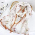 Detailed view of the elegant floral silk scarf, showing delicate print and orange border. - RY-17