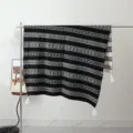 Detailed view of the black and white bohemian knit throw blanket with fringe tassels. - Night Silver Grain / Silver Gray