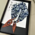 Vista dettagliata di un foulard in seta vintage con stampa cachemire e fibbia di perle. - Paisley Blu Scuro