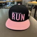 Primer plano detallado de una gorra snapback hip-hop negra y rosa con bordado. - Ajustable / Visera rosa corona negra [visera plana RUN]
