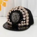 Cappellino da baseball punk nero con testa di leone in metallo e bottoni dorati. - Testa di leone