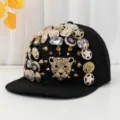 Cappellino piatto nero decorato con bottoni barocchi di lusso, strass e un leopardo. - Testa di leopardo con perline colorate
