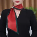 Close-up detail of a stylish red and green silk scarf with rhinestone buckle for women. - Green Edge Bright Red