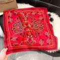 Detailed view of a vibrant red paisley and polka dot pattern on a silk-like square scarf - QQ-4