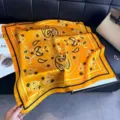 Close-up detail of high-quality orange silk scarf featuring intricate paisley and floral motifs - QQ-5