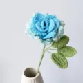 Handmade crochet blue rose flower detail view, knitted floral bouquet stem and green leaves. - Gradient Blue