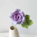 Handmade crochet purple rose flower with green leaves in a white ceramic vase detail shot - Gradient Purple