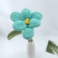 Detail shot of handmade crochet woolen flower in a white vase, delicate craft and vibrant color. - Blue Series B