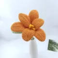 Handmade crochet flower detail showing orange petals and delicate yellow stamen craftsmanship. - Orange Series B