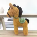 Handmade crochet horse plush toy, yellow body with brown mane and green saddle variant. - Orange