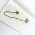 Handgemaakte haakgaren boekenlegger met paarse bloem en groene stengel, leuke accessoire. - Licht sneeuwmave
