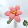 Closeup detail of handmade crocheted pink flower with yellow stamen in white vase decor. - Pink Series B