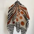 Close-up view of a lightweight abstract patterned square scarf, showing fine texture and artistic print. - ZS-5