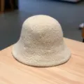Gros plan d'un chapeau de pêcheur en laine beige confortable sur une table en bois, détail d'hiver. - Réglable / Blanc