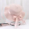 Détail de chapeau de paille rose avec voile en maille large et nœud ruban élégant. - Taille unique / Rose