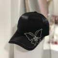 Detailed view of a chic black baseball cap featuring sparkling rhinestone butterfly embellishment. - Adjustable / Black