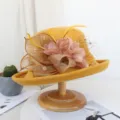 Gros plan sur le chapeau en feutre de laine jaune avec filet, fleurs et plumes. - Réglable / Jaune