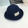 Vue rapprochée du chapeau cloche en tricot bleu foncé avec un patch tissé stylé. - M (56-58cm) / Bleu marine