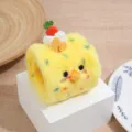 Primo piano del giocattolo per gatti in peluche rotolo svizzero giallo con musetto di pulcino. - Piccolo Pulcino Giallo