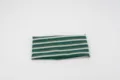 Detailed view of green and white striped knit headband, stretchy fabric texture close-up. - Green/White