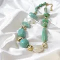 Close-up detail of trendy green resin irregular beads and gold metal texture necklace. - Emerald Green