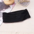 Detailed close-up of the black knitted wide headband showing delicate textured wave edge fabric. - Black
