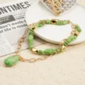 Detailed shot of multi-layer beaded necklace with green stones and gold chain elements on display. - Yellow-Green