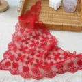 Red lace triangle scarf detail view with delicate floral embroidery and elegant wavy edges. - Red